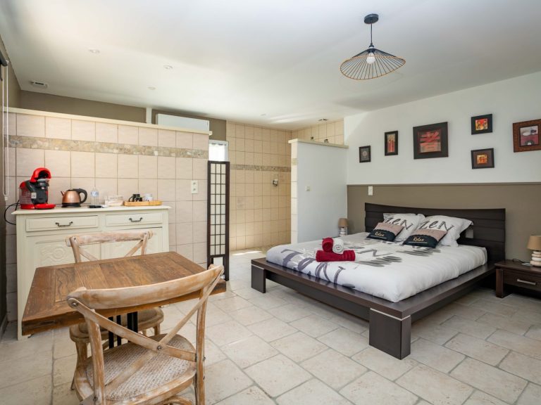 Chambre double spacieuse avec patio privé, climatisation et décoration soignée, idéale pour un séjour en couple.