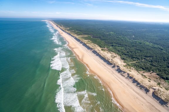 Plage sauvage de Charente-Maritime bordée de forêt, idéale pour les balades.